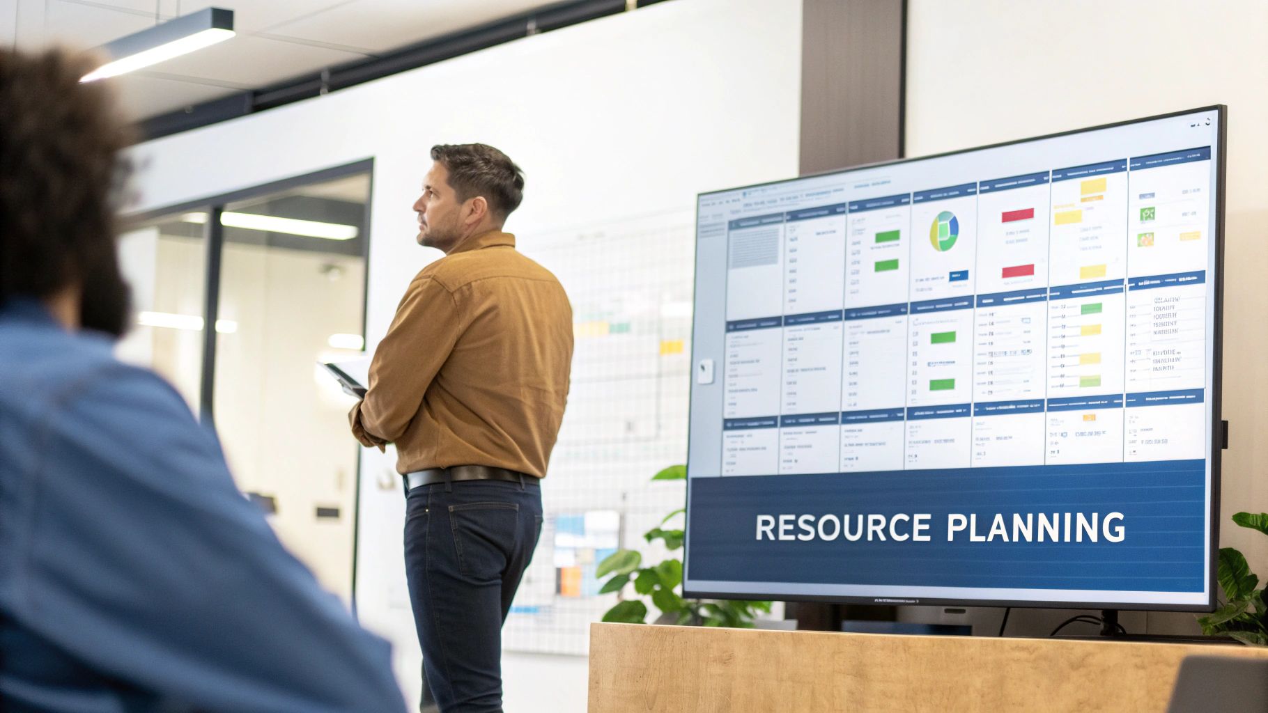 A team collaborating around a computer screen showing data analytics, representing resource planning software in action.