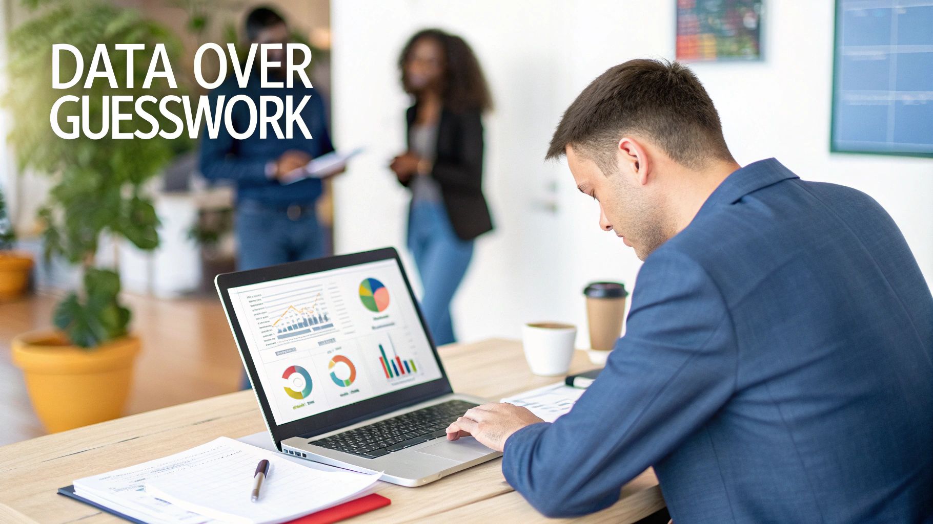 A man in a suit analyzes charts and graphs on a laptop, working in an office.