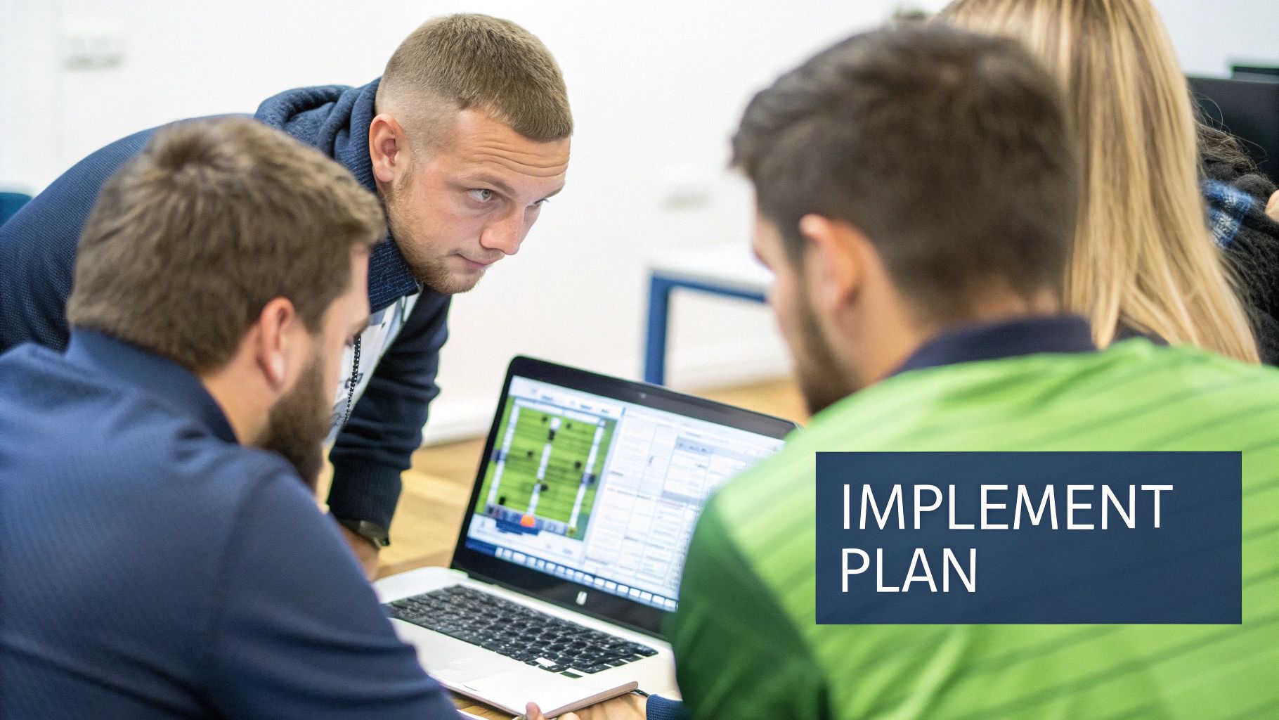 Team members collaborating around a desk with laptops and documents.